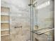 Modern shower with frameless glass, tiled walls, shower niche, and handrails at 4818 Grier Farm Ln, Charlotte, NC 28270