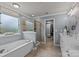 A luxurious bathroom with a soaking tub, walk-in shower, double vanity, and access to a walk-in closet at 5030 Lily Pond Cir, Waxhaw, NC 28173