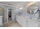 A well-lit bathroom featuring a double vanity with white cabinets and decorative wallpaper at 5030 Lily Pond Cir, Waxhaw, NC 28173