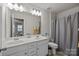 A bright bathroom featuring a double vanity, shower and bath combo, and a large mirror at 5030 Lily Pond Cir, Waxhaw, NC 28173