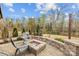 Cozy backyard fire pit area featuring a brick surround, chairs, and lush landscaping at 5030 Lily Pond Cir, Waxhaw, NC 28173