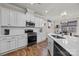 Bright kitchen with white cabinets, a black gas stove, and quartz countertops at 5030 Lily Pond Cir, Waxhaw, NC 28173