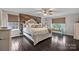 Serene bedroom suite with plush bedding, wood accent wall and dark stained wood floors at 5030 Lily Pond Cir, Waxhaw, NC 28173