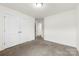 A vacant bedroom features neutral carpet and a closet for storage at 5108 Puclerton Dr, Charlotte, NC 28215