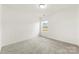 A vacant bedroom features neutral carpet and a window providing natural light at 5108 Puclerton Dr, Charlotte, NC 28215