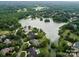 Stunning aerial view of a neighborhood with a lake surrounded by lush greenery and luxury homes at 5811 Old Well House Rd, Charlotte, NC 28226