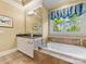 Bathroom featuring a jacuzzi tub, white cabinets, a window with blue curtains, and tile flooring at 5811 Old Well House Rd, Charlotte, NC 28226