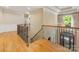 Spacious upstairs hallway with hardwood floors, iron railing, and a view of the entryway chandelier at 5811 Old Well House Rd, Charlotte, NC 28226