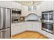 Well-equipped kitchen featuring stainless steel appliances, white cabinets and hardwood floors at 5811 Old Well House Rd, Charlotte, NC 28226