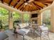 Covered outdoor living space with stone fireplace and ample seating at 5811 Old Well House Rd, Charlotte, NC 28226