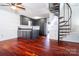 Kitchen with dark cabinets, white subway tile backsplash, hardwood floors, and spiral staircase at 6199 Timberlane Ter, Hickory, NC 28601
