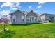 Lovely backyard with healthy green lawn and stone patio visible through the trees at 6276 Artigas Dr, Fort Mill, SC 29707