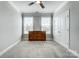 Neutral bedroom featuring two windows with blinds, a ceiling fan, and a beautiful wooden dresser at 6276 Artigas Dr, Fort Mill, SC 29707