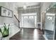 Bright entryway showcasing double doors, hardwood floors, and a staircase with white trim at 6276 Artigas Dr, Fort Mill, SC 29707