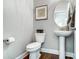 The half bath includes a pedestal sink, elegant fixtures, and a coastal-themed artwork for added charm at 6276 Artigas Dr, Fort Mill, SC 29707