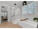 Bright bathroom featuring a soaking tub and a glass shower with black fixtures and herringbone floors at 7322 Bay Ridge Dr, Denver, NC 28037