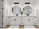 Bathroom with double vanity, white cabinets, marble countertops, and round mirrors with black trim at 7322 Bay Ridge Dr, Denver, NC 28037