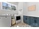 Bright laundry room featuring modern appliances, decorative floor tiles, and a window providing natural light at 7322 Bay Ridge Dr, Denver, NC 28037