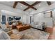 Open concept living room featuring hardwood floors, wooden beam ceilings, and a view into the modern blue kitchen at 7322 Bay Ridge Dr, Denver, NC 28037
