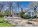 Backyard view showcasing a concrete patio and seating area, surrounded by lush greenery and mature trees on a sunny day at 842 Mary Knoll Ct, Rock Hill, SC 29730