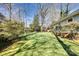 A lush green backyard featuring mature trees and landscaping surrounding a light-colored home at 842 Mary Knoll Ct, Rock Hill, SC 29730