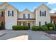 Inviting townhome featuring a well-manicured lawn, brick accents, and a convenient single-car garage at 9068 Cinnabay Dr, Charlotte, NC 28216