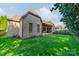 Stunning backyard featuring lush green grass and a gray brick home with a cozy outdoor seating area at 913 Dacavin Dr, Charlotte, NC 28226