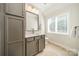 This bathroom has a vanity with gray cabinetry and a large mirror, complemented by modern lighting at 913 Dacavin Dr, Charlotte, NC 28226