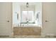 Relaxing bathroom with a soaking tub, tiled surround, and natural light at 913 Dacavin Dr, Charlotte, NC 28226