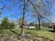 Wide shot of a home with a lawn and trees in the foreground under a clear blue sky at 915 2Nd St, Kings Mountain, NC 28086