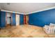 A large bedroom featuring carpeted floors, blue walls, and multiple entry doors at 1008 High Wedge Rd, Shelby, NC 28152
