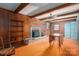 Living room with a wood burning fireplace, wood beam accents, and wood paneled walls at 1008 High Wedge Rd, Shelby, NC 28152