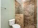 A bathroom with a textured tile shower, grab bars, and tile flooring, ensuring safety and style at 1026 Eagles Nest Ln, Fort Mill, SC 29707
