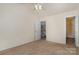 This is a bedroom with neutral walls, beige carpet, and a partially open door at 1026 Eagles Nest Ln, Fort Mill, SC 29707