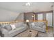 Upstairs living area featuring two gray sofas, a coffee table, ceiling fan, and neutral decor at 1026 Eagles Nest Ln, Fort Mill, SC 29707
