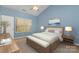 The main bedroom with a ceiling fan, a cozy bench at the foot of the bed, and two large windows at 1026 Eagles Nest Ln, Fort Mill, SC 29707