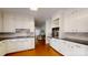 Well-lit kitchen featuring white cabinetry, black countertops, and hardwood flooring at 116 Jonas Dr, Lincolnton, NC 28092