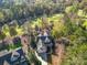 Stunning aerial view of a two-story home with an attached garage, set amidst lush greenery and a golf course backdrop at 124 Gatlin Knl # 11, New London, NC 28127