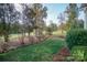Large backyard featuring a level lawn, mature trees, and established landscaping at 124 Gatlin Knl # 11, New London, NC 28127