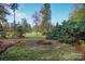 Landscaped backyard with a custom fire pit, mature trees, and level lawn at 124 Gatlin Knl # 11, New London, NC 28127