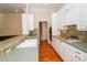Well-lit kitchen featuring white cabinetry, tile countertops, gas range, and hardwood floors at 124 Gatlin Knl # 11, New London, NC 28127