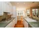 Bright kitchen features white cabinets, wood floors, and views of a breakfast nook and a sunroom at 124 Gatlin Knl # 11, New London, NC 28127