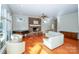 Cozy living room features hardwood floors, stone fireplace, piano, and comfortable white sofas at 124 Gatlin Knl # 11, New London, NC 28127