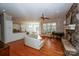 Open-concept living room boasts a stone fireplace, hardwood floors, and white leather furniture at 124 Gatlin Knl # 11, New London, NC 28127