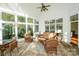 The bright sunroom is encased in windows and features comfortable wicker furniture at 124 Gatlin Knl # 11, New London, NC 28127