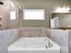 Relaxing soaking tub with tile surround and large window at 1501 Allegheny Way, Waxhaw, NC 28173