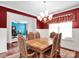 Formal dining room with red accent wall, decorative chairs, and chandelier at 1501 Allegheny Way, Waxhaw, NC 28173
