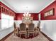 Elegant dining room with a decorative light fixture, red walls and ornate furniture at 1501 Allegheny Way, Waxhaw, NC 28173