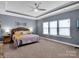 This primary bedroom features carpet floors, a ceiling fan, and large windows for ample natural light at 1501 Allegheny Way, Waxhaw, NC 28173