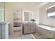 Modern bathroom leading to bedroom with soaking tub and illuminated mirror at 15115 Rocky Bluff Loop, Davidson, NC 28036
